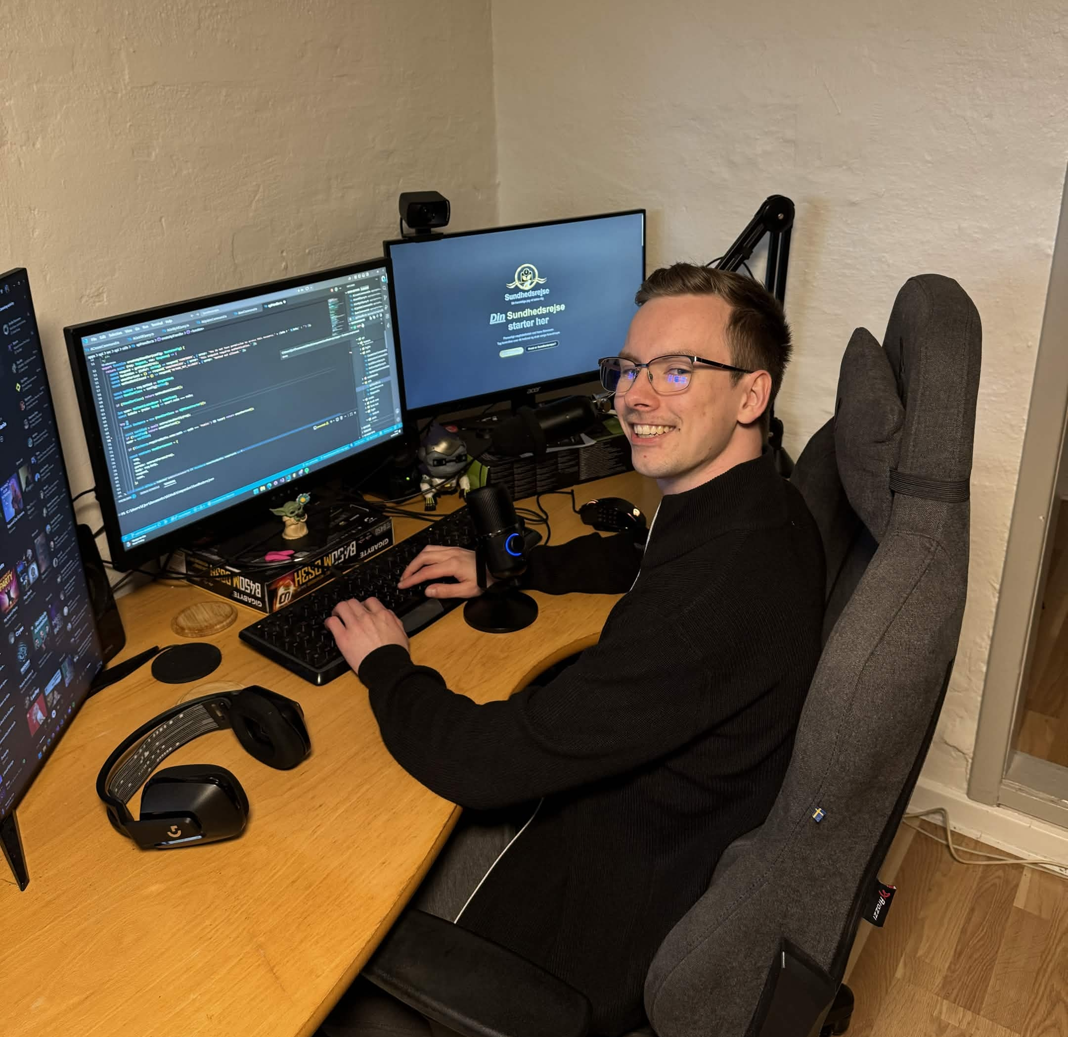 Daniel ved sit skrivebord der smiler til kameraet